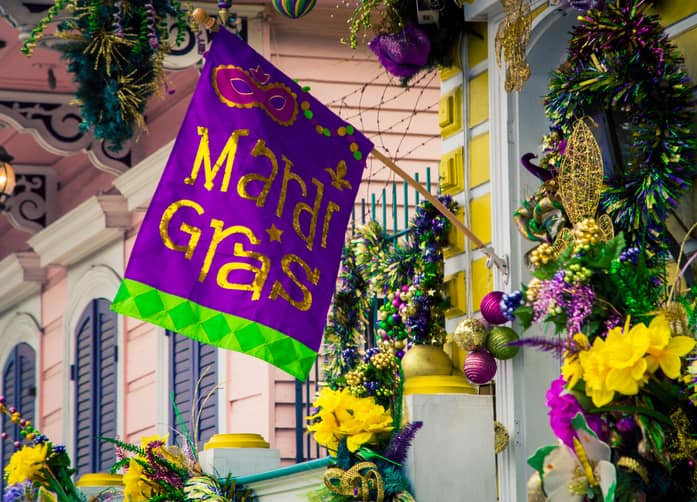 A home in New Orleans decorated for Madrdi Gras with purple, green, and yellow decorations.